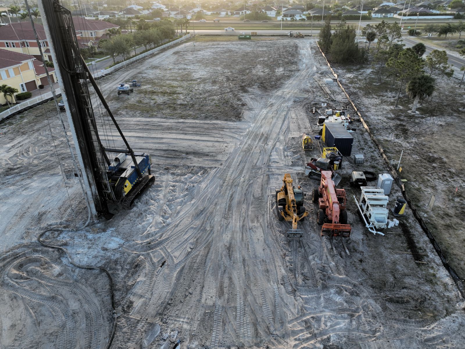 Pile driver on the Lake Shadroe site at golden hour, April 2026